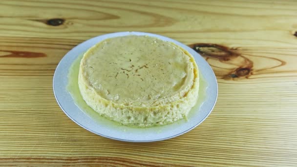 Ovanifrån på hela rundan hemlagad flan serveras med socker sirap på vit tallrik — Stockvideo