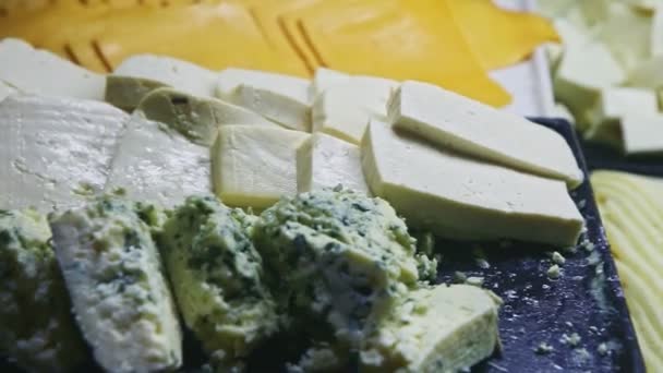 Panorama zbliżeniowa na płycie asortymentowej z różnymi rodzajami sera w plasterkach — Wideo stockowe