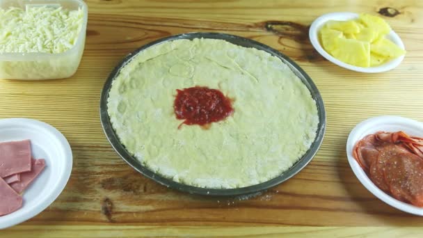 Top view zoom out from round pizza dough with oil drops on wooden table — Stock Video