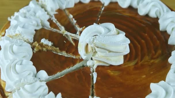 Close up panorama para baixo no bolo de caramelo redondo com creme branco dividido em partes — Vídeo de Stock