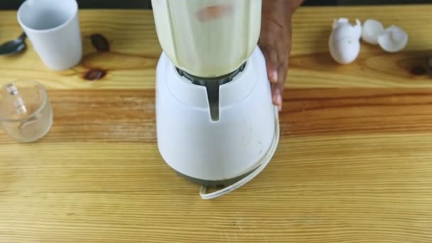 Vista superior sobre el hombre con las manos sostiene licuadora eléctrica mezclando leche condensada y huevos — Vídeos de Stock