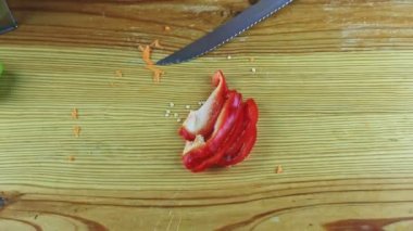 Yukarıdan insan eli yakın çekim bıçakla kesilmiş tatlı kırmızı dolma biber.