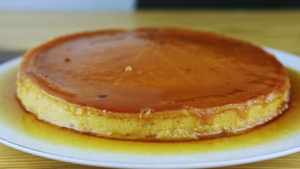 Closeup man hands by knife slice round homemade soft flan with caramel syrup — Stock Video