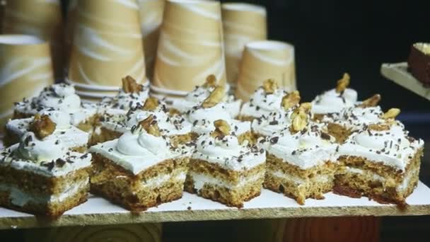 Panorama de primer plano en el surtido de piezas de pastel dulce decorado con crema blanca — Vídeos de Stock