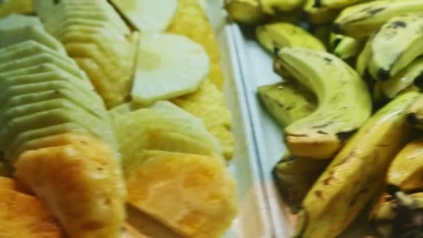 Zbliżenie panorama z dojrzałych oczyszczonych plasterków ananasa do dużej grupy bananów — Wideo stockowe
