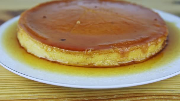 Slowly zoom out from sliced round homemade soft flan with caramel syrup — Stock Video