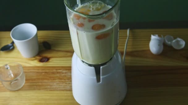 Top view on electric blender glass chalice with condensed milk and eggs — Stock Video