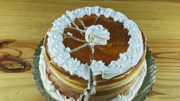 Zoom in at round caramel cake decorated with white cream divided into parts — Stock Video