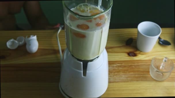 Ovanifrån på elektrisk mixer glas kalk med kondenserad mjölk och ägg — Stockvideo