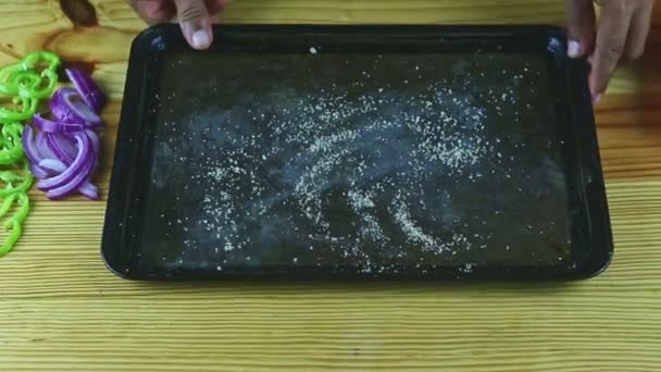 Top view zbliżenie na rękach człowieka umieścić połowę surowego marynowanego kurczaka na naczyniu do pieczenia — Wideo stockowe