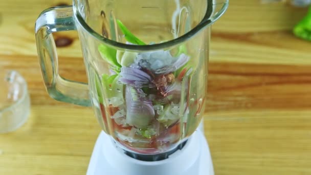 Close-up op man door handen neemt glas blender kelk met gehakte groenten — Stockvideo