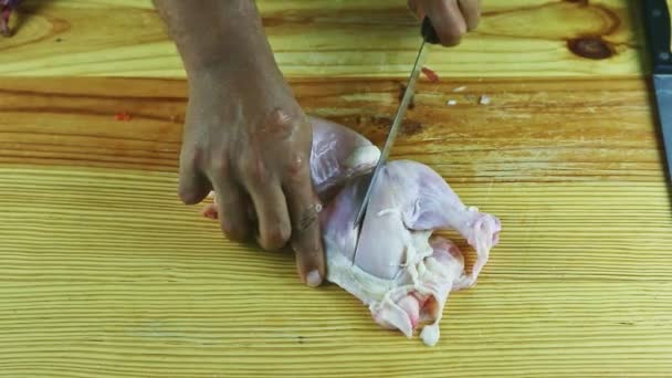 Vista superior em mãos de homem por faca metade de frango cru na mesa de madeira — Vídeo de Stock