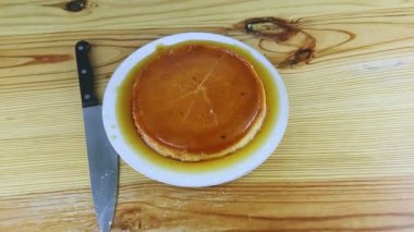 Üst manzara, beyaz tabakta karamel şurubuyla dilimlenmiş ev yapımı turtaya yakınlaştır.