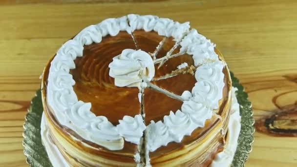 Зум из круглого карамельного торта, украшенного белым кремом, разделенного на части — стоковое видео