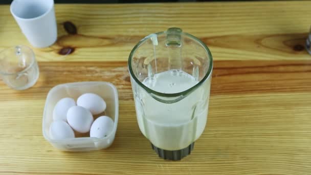 Shora pohled na muže ruce vylévá čistou vodu do mixéru kalich s kondenzovaným mlékem — Stock video