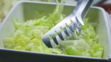 Yemek katında doğranmış yeşil marulla birlikte beyaz kase yakın plan görüntüsü