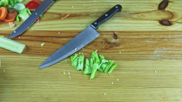 Vista superior sobre mãos de homem organizar mesa de madeira com pimenta verde fatiada e facas — Vídeo de Stock