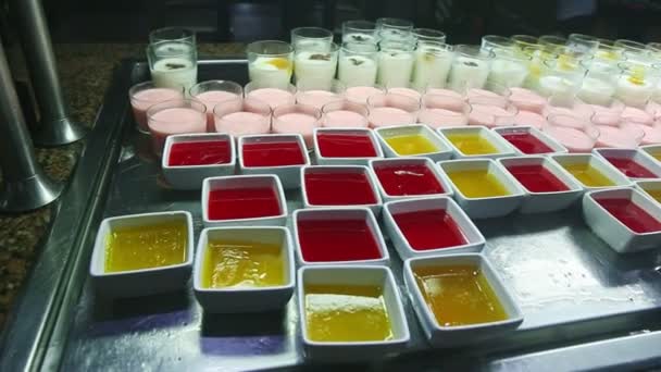 음식 법원에서 과일 젤리와 화려 한 요구르트를 잔뜩 곁들인 파노라마를 천천히 먹는 모습 — 비디오