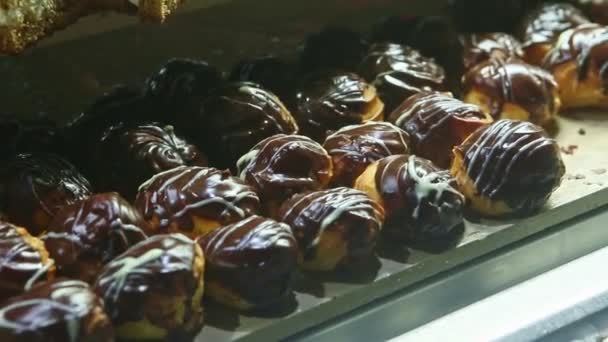 Panorama zbliżenie w asortymencie różnych eklerki czekoladowe i kawałki ciasta — Wideo stockowe
