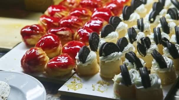 Closeup panorama pada berbagai macam potongan kue manis yang berbeda dan eklair buah — Stok Video
