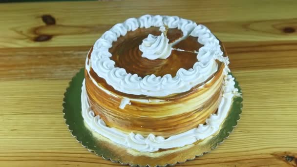 Close-up em mãos de menina por faca cortar bolo de caramelo redondo decorado com creme branco — Vídeo de Stock
