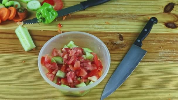Rundblick von oben aus Plastikschüssel mit Gemüsesalat, serviert mit großem Messer — Stockvideo