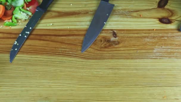 Top view on man by hands sätter gröna salladsblad bredvid stora knivar på bordet — Stockvideo