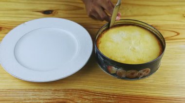 Yuvarlak ev yapımı turtayı ahşap masa üzerinde metal pişirme kabına koyuyoruz.