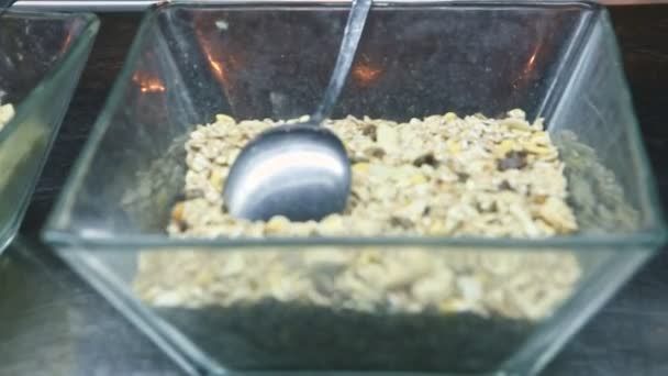 Gros plan foyer dans un bol en verre transparent avec de l'avoine céréales granola avec des fruits secs — Video