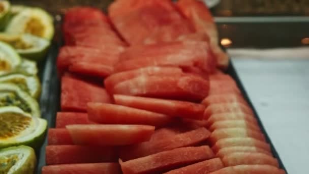 Close-up panorama in het assortiment met gesneden watermeloen en helften passievruchten — Stockvideo