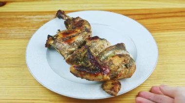 İnsanoğlunun üst görüntüsü beyaz tabağı taşır, yarısı baharatlı tavukta kızarır.