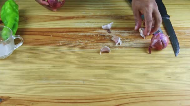 Shora pohled na muže ruce odnést fialové cibule a kousky česneku z dřevěného stolu — Stock video