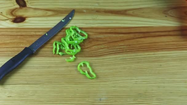 Vista superior em mãos de homem por faca mover fatias de pimenta verde e começar a cortar cebola — Vídeo de Stock