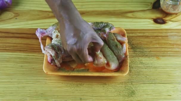 Widok z góry na ręce człowieka posypać przez suche oregano połowa surowego kurczaka na płycie z tworzywa sztucznego — Wideo stockowe