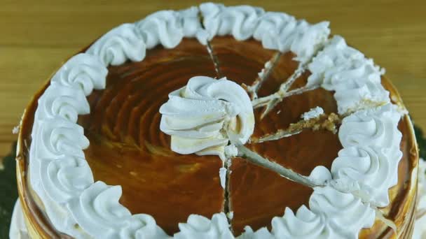 Top view zoom out from round caramel cake with white cream divided into parts — Stock Video