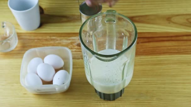 Bovenaanzicht op mensenhanden open metalen blik met gecondenseerde melk naast blender kelk — Stockvideo