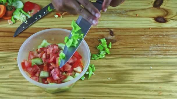 Vue de dessus sur l'homme mains par couteau mettre des morceaux de poivre vert dans un bol en plastique profond — Video