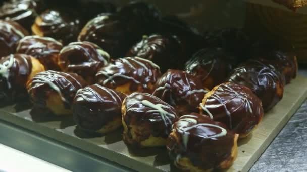 Panorama zbliżenie w różnych eklerkach słodkiej czekolady w żywności sąd asortyment — Wideo stockowe
