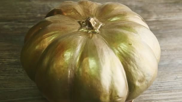 Gran calabaza de halloween de oro pesado girando en torno a la mesa de madera — Vídeos de Stock