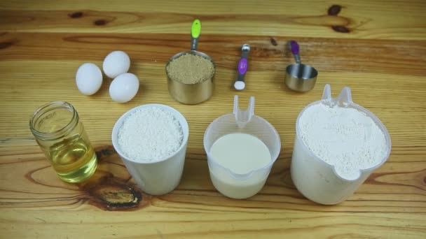 Top view at wooden table served with many different ingredients to make dough — Stock Video