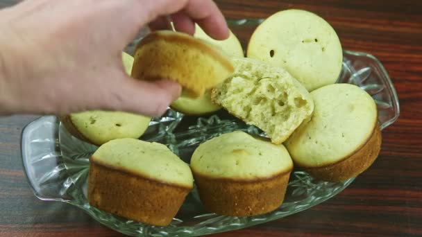 Closeup shot from above woman hand turns broken muffin served on whole cupcakes — Stock Video