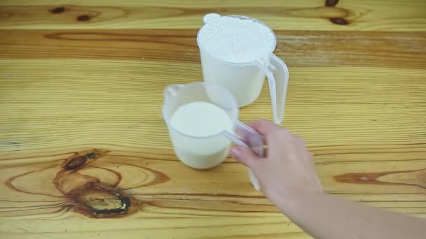 Top view on woman by hand take away small ewer with milk and large ewer with flour — Stock Video