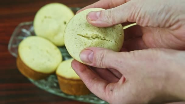 Vrchní pohled detailní žena po ruce pomalu brzdí celý bílý muffin s kokosem — Stock video