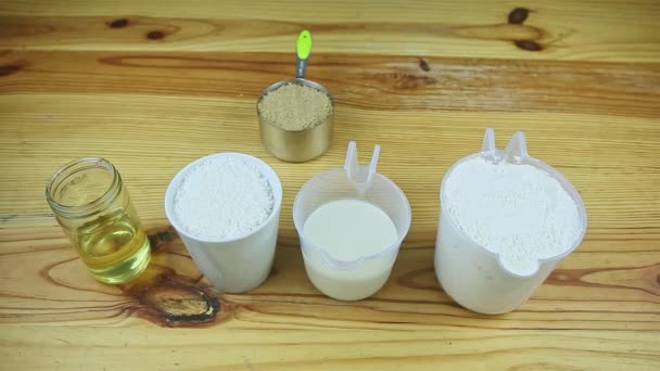 Top view at wooden table served with many different ingredients to make dough — Stock Video
