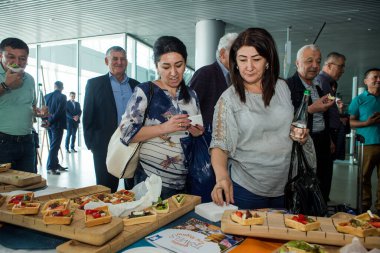 LVIV, UKRAINE - 24 Mayıs 2018 Birçok yolcu 24 Mayıs 'ta Lviv havaalanı salonundaki ücretsiz dezenfekte masasından atıştırmalık ve içecek denedi