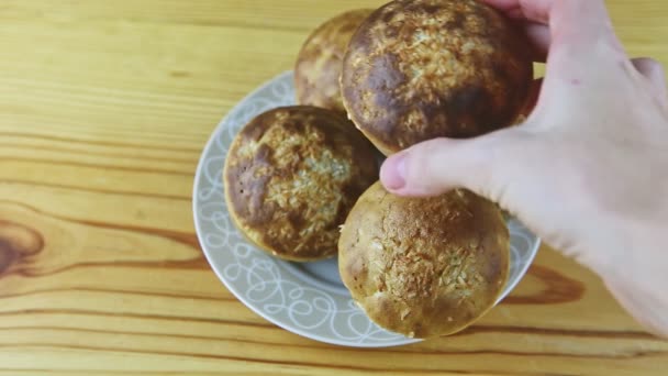 Shora pohled detailní záběr na ženu ručně dává a bere pryč jeden celý muffin s kokosem — Stock video