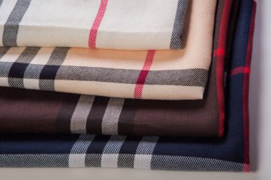 Katlanmış sütlü, bej, kahverengi ve siyah dikişsiz siyah desenli siyah, beyaz ve kırmızı şeritli eşarp setine yakın çekim