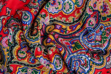 Üst taraf, parlak doğulu süs eşarbıyla buruşmuş kırmızı kadın pamuk eşarbına yakın plan.