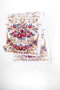 Üst manzara düz beyaz pamuk atkı üzerine uzanır püsküllü ve parlak çiçekli süs