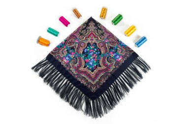 Üst görünüm düz siyah pamuk atkı üzerinde uzanır püsküllü ve parlak doğu süsü ile büyük mavi güller ve beyaz arkaplanda izole Arap deseni